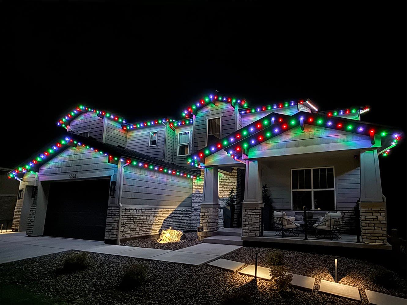 The same home with red, green, and blue lights along every roofline for Christmas